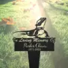 Black metal memorial garden stake with a lizard silhouette and script text reading "In Loving Memory Of Parker Chavis 1971-2024" stuck in grassy yard