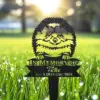 233-3 Black metal garden memorial stake shaped like a smiling fluffy dog with text “In Memory Of Tictac Nov 5 2018-May 2024” placed in dewy grass at sunrise