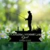 Silhouette of a man fishing on a memorial sign reading "In loving memory of Dad 1960-2025" against a blurred green background with daisies