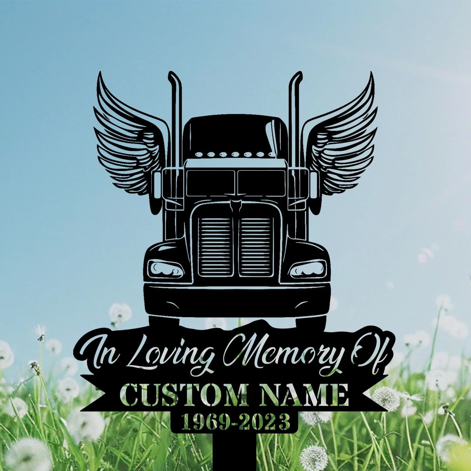 Black silhouette memorial sign of a semi truck with wings above script text “In Loving Memory Of” and placeholder “CUSTOM NAME 1969-2023” against a blue sky and dandelion field