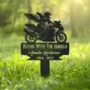 Black metal grave marker in grass showing a winged motorcyclist and text “Riding With The Angels, Amalin Robinson, 1962 - 2025”