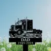Black memorial yard sign showing a semi truck silhouette with script text "In Loving Memory Of" and block text "DAD 1949-2024" against a grassy dandelion field and blue sky