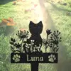 Black metal garden stake silhouette of a cat amid wildflowers with paw prints and the name "Luna" against sunlit grass