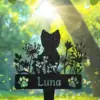 Metal garden silhouette of a cat among wildflowers with paw prints and the name Luna, backlit by sun through trees