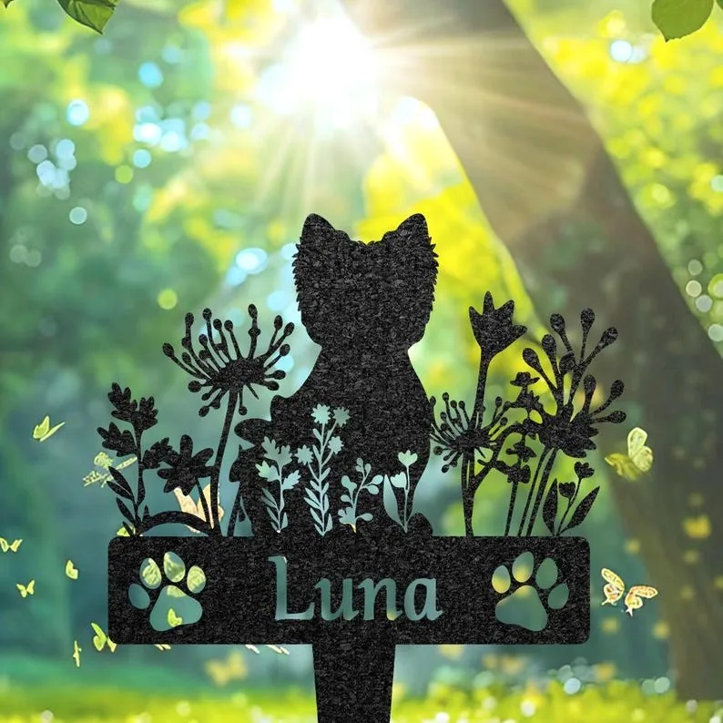 Metal garden silhouette of a cat among wildflowers with paw prints and the name Luna, backlit by sun through trees