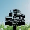 303 Black memorial lawn sign showing a bulldozer illustration and text "In Loving Memory Of DAD 1949-2024" against a blue sky and dandelion field