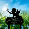 Silhouette of a winged baby reaching for a butterfly above a memorial plaque in a sunny grassy field with blue sky and wildflowers, text reads "I'll hold you in my heart until I can hold you in heaven 2026"
