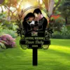 341 Garden memorial yard sign showing silhouetted parents holding a baby with angel wings and halo, text “In Loving Memory of Bean Baby 2025,” placed on a lawn with flowers and trees