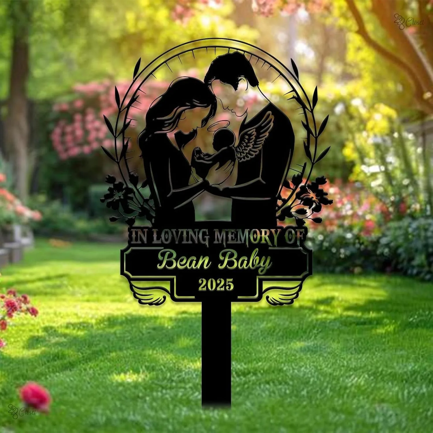 343 Black metal memorial yard sign in a garden showing parents holding an angelic baby with text “In Loving Memory of Bean Baby 2025”
