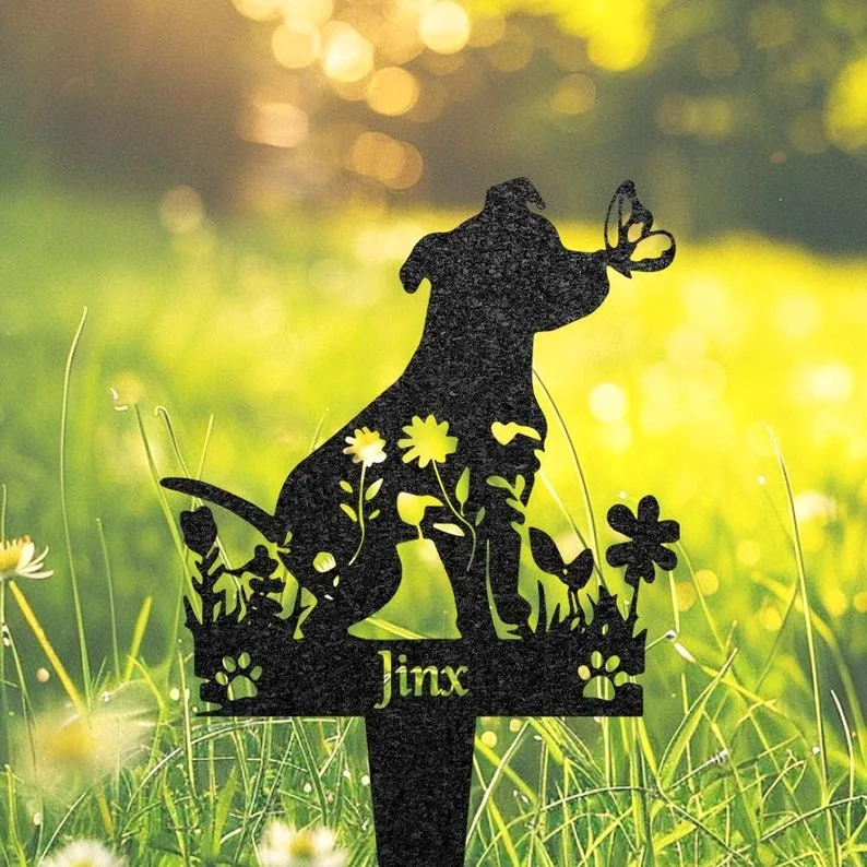 Black metal garden stake silhouette of a dog with flowers, paw prints, and a butterfly, name 'Jinx' cut out, placed in grassy yard