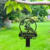 351 Black memorial lawn sign with motocross rider and checkered flags reading "In Loving Memory of Jacob Henderson 1956 - 2024" staked in a green backyard garden