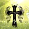 Black angel wing cross yard sign with halo, name "Juan Rollins" across the cross and years 1980–2025, placed in grassy outdoor setting