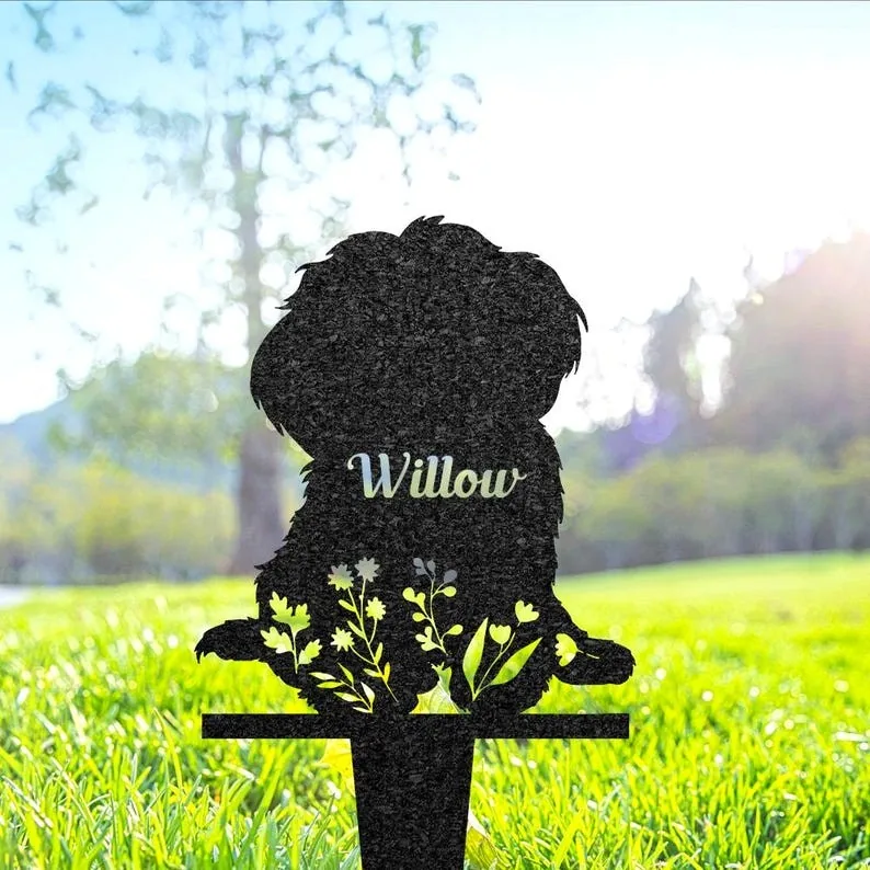 Black metal garden silhouette of a sitting dog with floral cutouts and the name "Willow," staked in sunlit grass