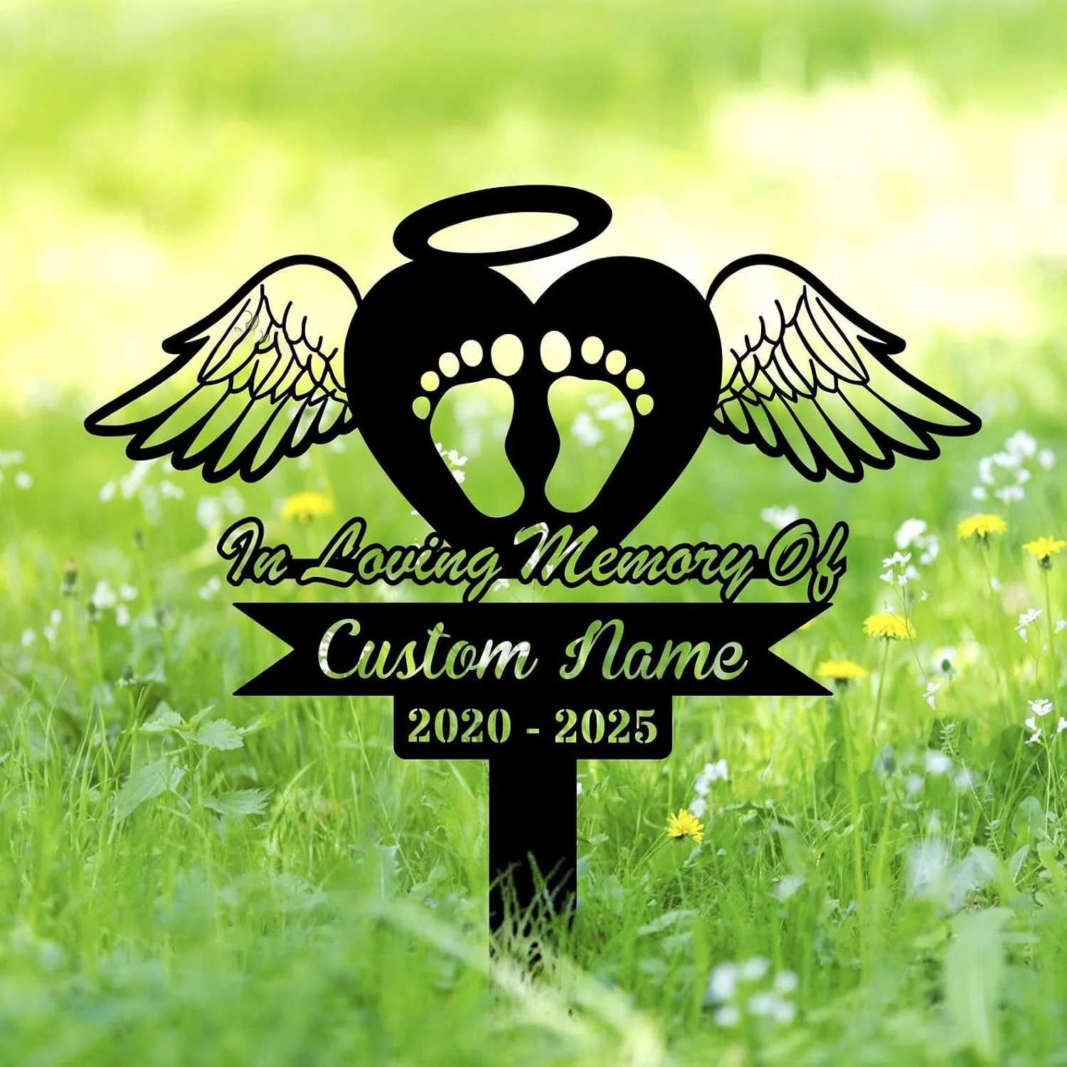 Black memorial lawn stake with angel wings, heart with baby footprints and halo reading "In Loving Memory Of" and "Custom Name" with years 2020 - 2025 on green grassy background