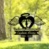 Black memorial yard sign with angel wings, heart and baby footprints reading "In Loving Memory Of" and customizable name with dates 2020 - 2025 in a grassy outdoor setting
