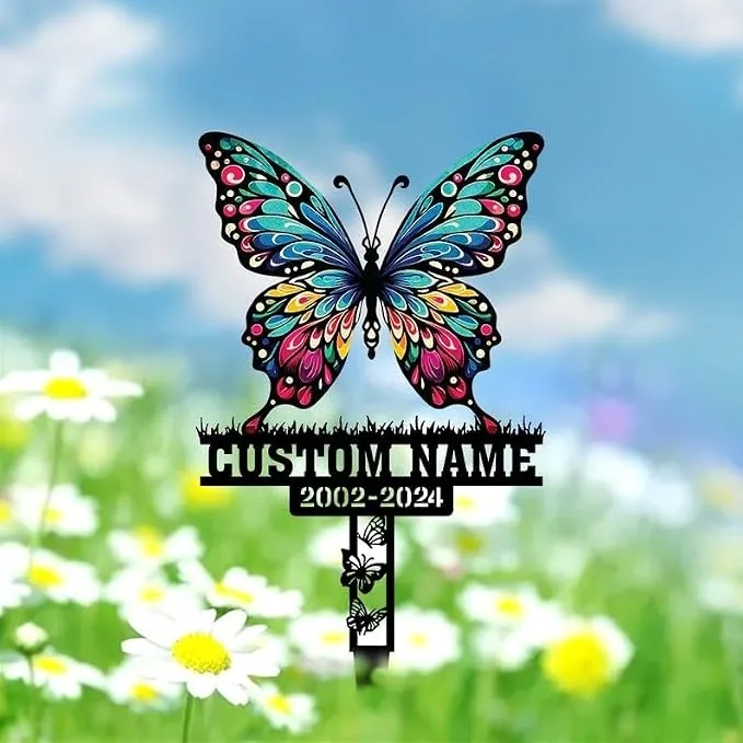 43 Colorful butterfly grave marker with decorative wings, placeholder text "CUSTOM NAME" and dates "2002-2024" over a grassy daisy field