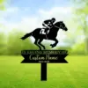 Black metal memorial yard sign with a jockey on a racing horse above text reading "In Loving Memory of" and customizable name and dates, placed in a green lawn