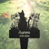 71-1 Black metal garden memorial stake shaped like a cat silhouette among flowers with the name "Aurora" and dates "2012-2024" set against sunlit grass