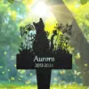 72-1 Black silhouette garden memorial stake showing two cats among flowers and butterflies with name "Aurora" and dates "2012-2024" against a sunlit green background