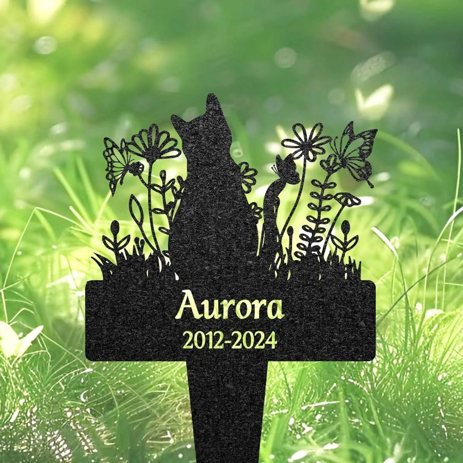 73-1 Black metal memorial garden stake shaped like a cat silhouette among flowers and butterflies with name "Aurora" and years "2012-2024" against grassy green background