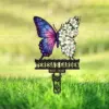 Garden memorial sign in grass with a butterfly: left wing galaxy pattern, right wing made of white lilies, black text reading "TERESA'S GARDEN" and years "1975 - 2025"