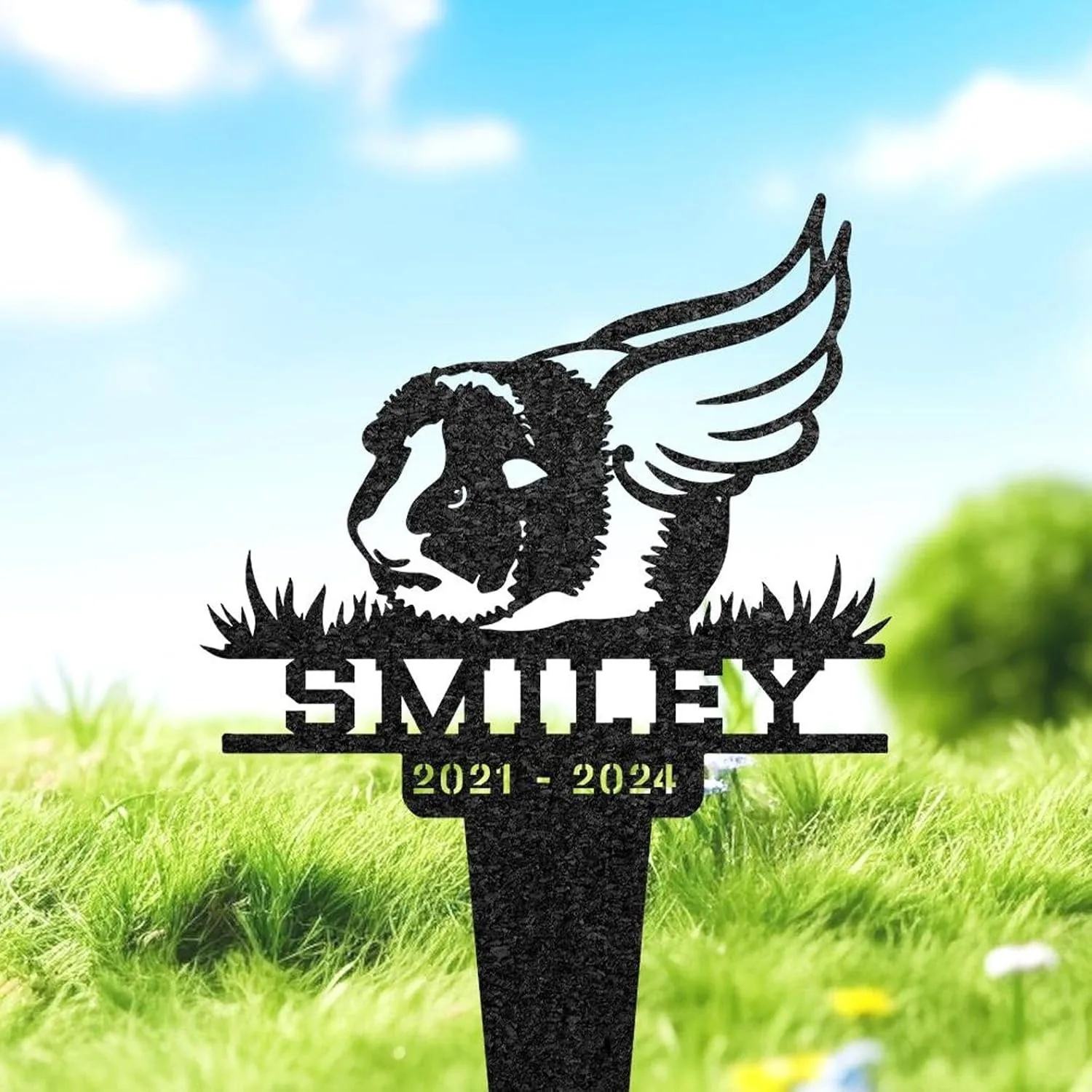 93-1 Black metal memorial yard stake showing a guinea pig with wings, grass details and name 'SMILEY' above dates '2021 - 2024' against a sunny grassy background