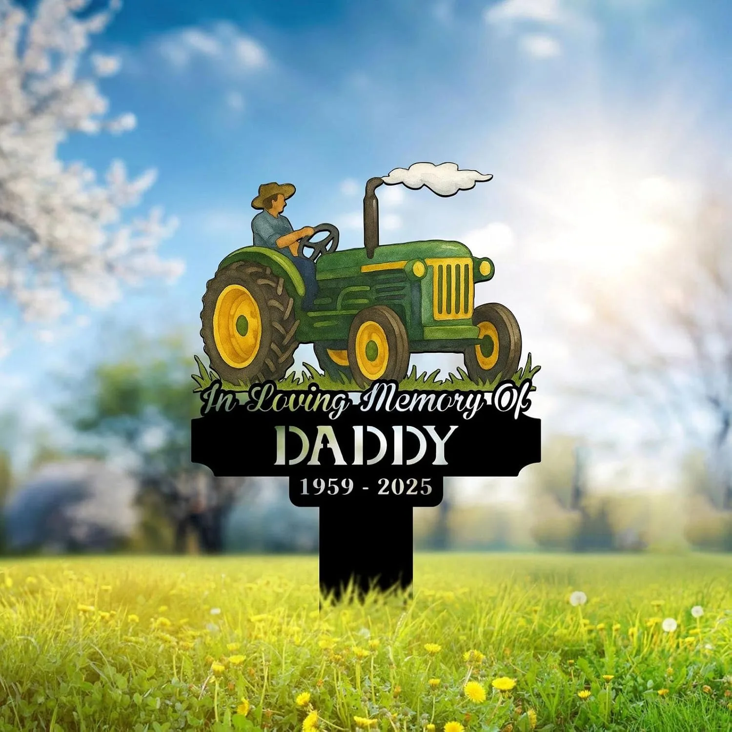 Memorial yard sign with a green tractor illustration and farmer, text reading "In Loving Memory Of DADDY 1959 - 2025" placed in a sunlit grassy field