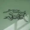 Black wire wall art of two hands connecting puzzle pieces with cursive text reading “You are my missing piece” on a pale green wall