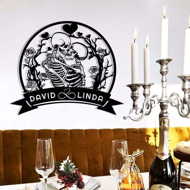 Black circular wall decal showing two embracing skeletons surrounded by roses and vines with banner reading ‘DAVID ♥ LINDA,’ above a dining table with candles and glassware