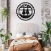 Bedroom with boho decor, rust-colored bedding, plants, and a round black metal wall sign reading ‘Anniversary’ featuring two cowboys on horseback holding hands