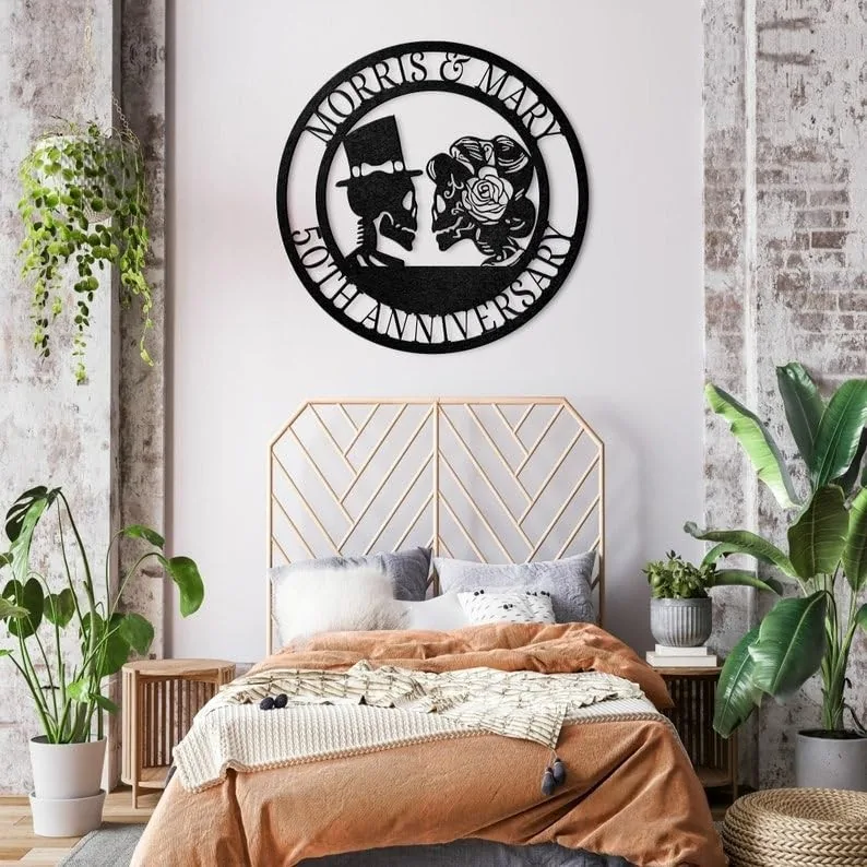 style-23.-Gothic-Skeleton-Couple-3 Modern bedroom with rust-colored bedding and plants, metal circular wall art above bed reading “Morris & Mary 50th Anniversary,” geometric headboard