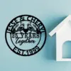Black circular wall plaque reading "Jesse & Cheryl" with two cardinals, "25 Years Together" and "EST. 1999" mounted on a light blue wall beside a white decorative house shelf