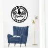 Black circular metal wall sign reading "Jesse & Cheryl" and "50 Years Together Est. 1974" with a couple silhouette, hanging above a blue lounge chair and gold floor lamp in a bright room