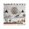 Rustic kitchen wall with wooden round metal sign reading “ROSA & IVAN” above a wooden countertop, pendant lights, open shelves, cutting boards, kettle and plants
