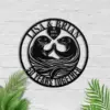 style-35.-Otter-Anniversary-1 Black metal wall art of two otters touching paws inside a circle reading "LISA & BRIAN" with a heart saying "EST. 1974" and "50 YEARS TOGETHER" on a white brick wall with green leaves