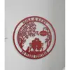 Red circular metal wall sign on a white wall showing a couple on a bench under a tree with a dog, text "Mike & Keri" at top, "Est 1974" on a hanging plaque and "50 Years Together" at bottom