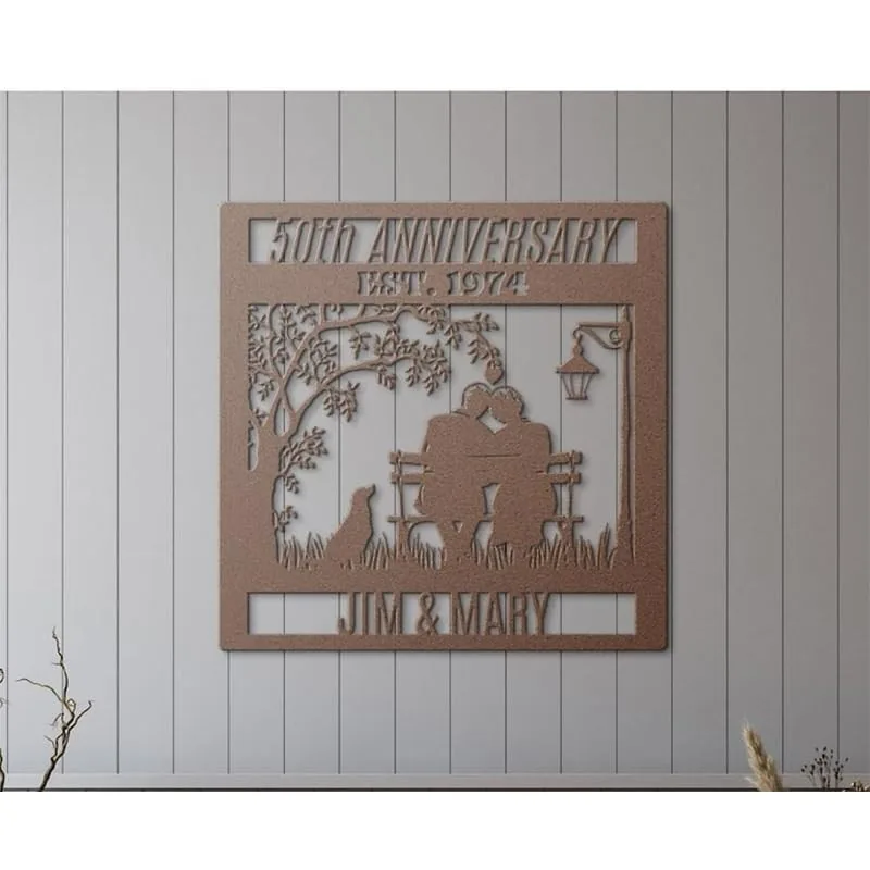 Metal wall plaque reading "50th Anniversary Est. 1974" with a couple sitting on a bench, a dog, tree and lamp silhouette, personalized "Jim & Mary", mounted on shiplap wall